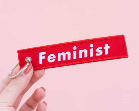 Red embroidered fabric keychain with the text &quot;Feminist&quot; embroidered in white